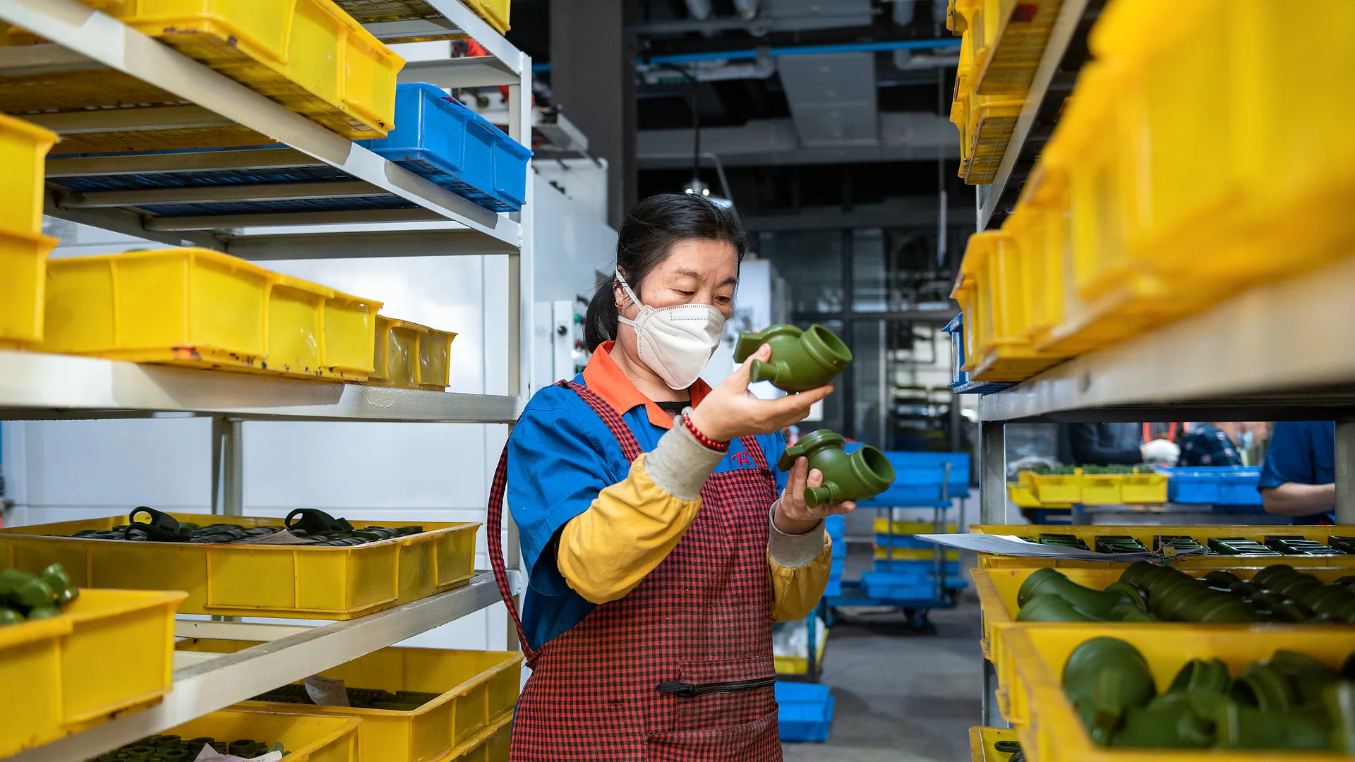 Worker visually inspecting finished cast components