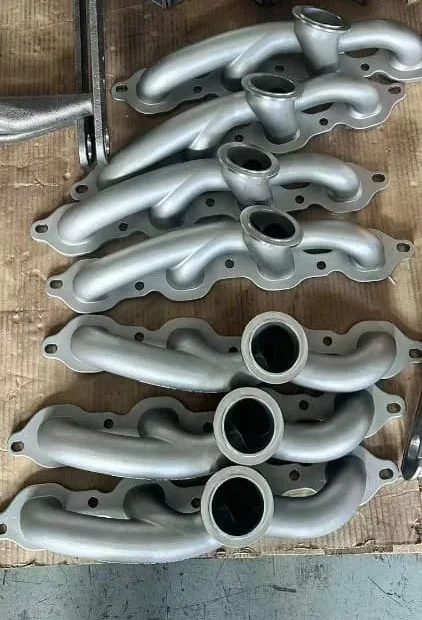 Finished 304 stainless investment-cast turbo exhaust manifolds arranged as a batch