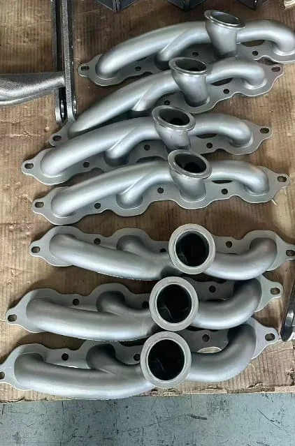Finished 304 stainless investment-cast turbo exhaust manifolds arranged as a batch
