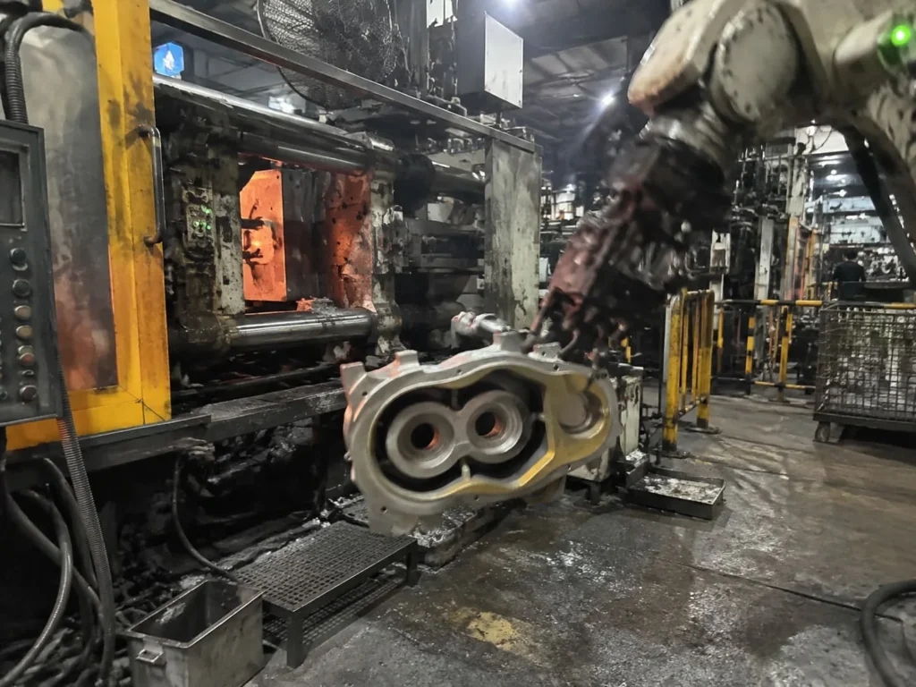 Die-cast equipment housing being handled at a production cell