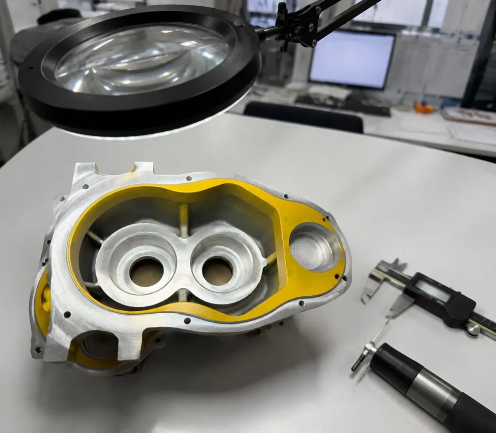 Equipment housing being checked on an inspection table with a caliper