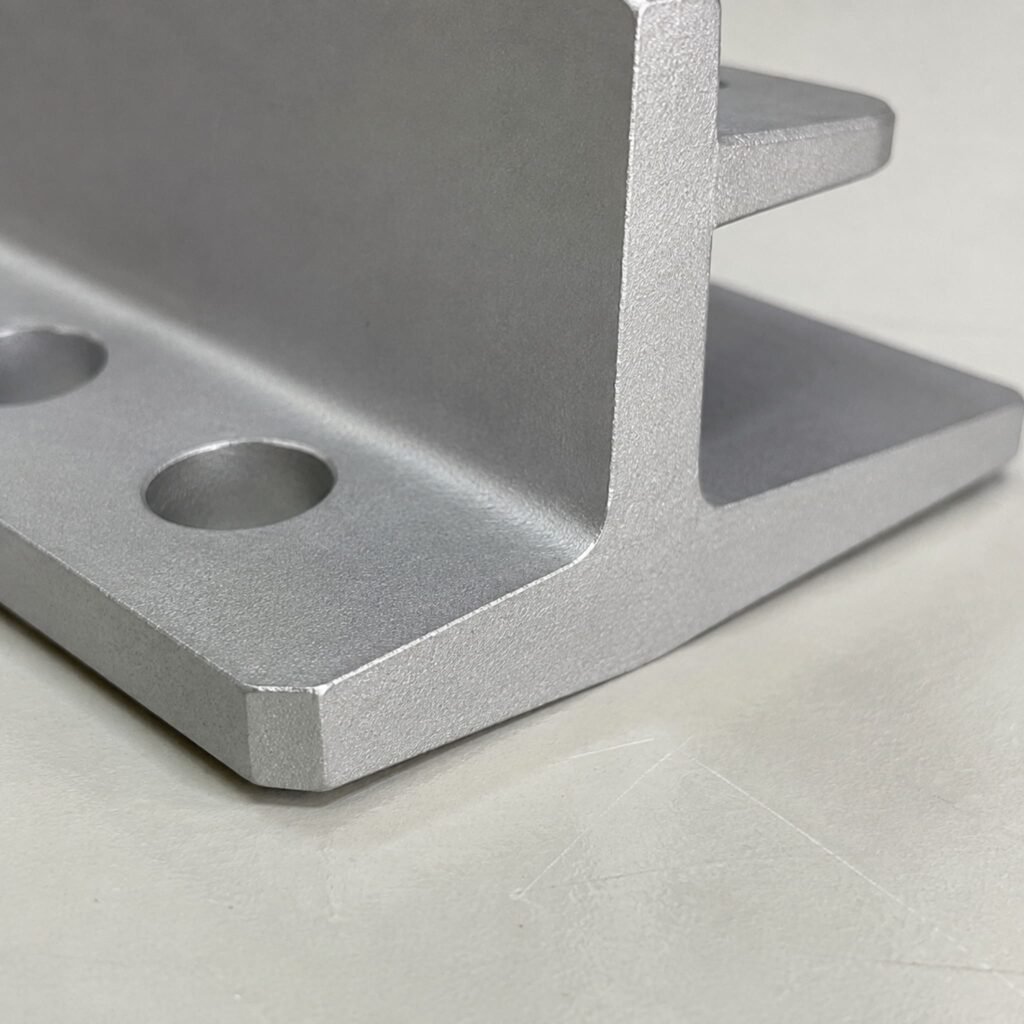 Close view of holes and reinforcing features on an A380 die-cast solar mounting bracket