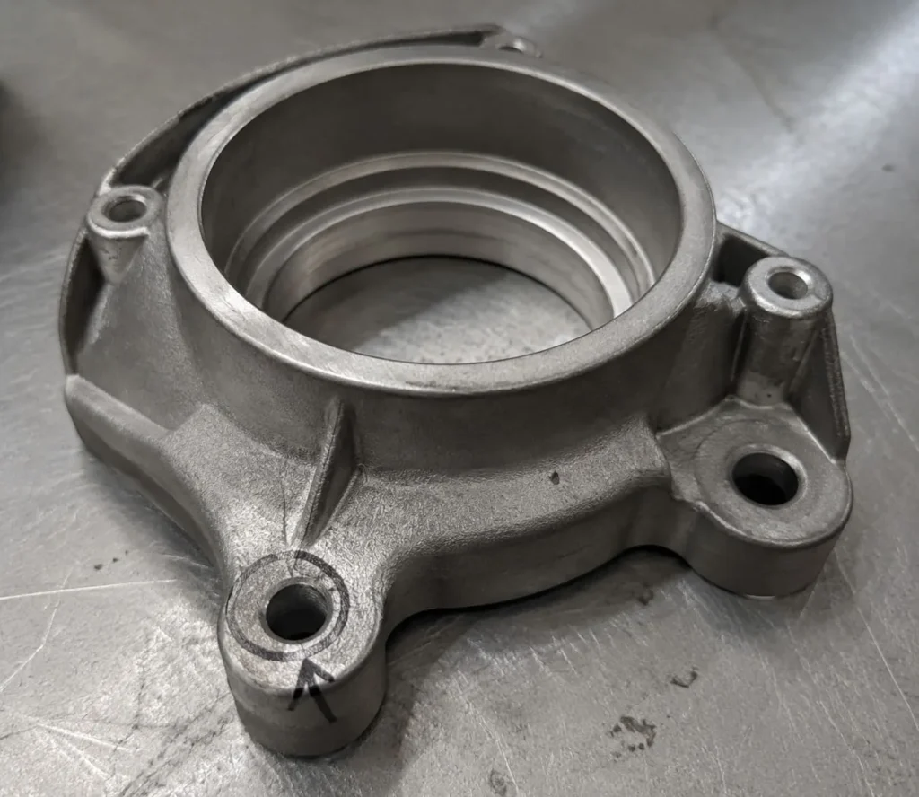 Finished ADC12 valve bracket with one assembly feature marked for dimensional review