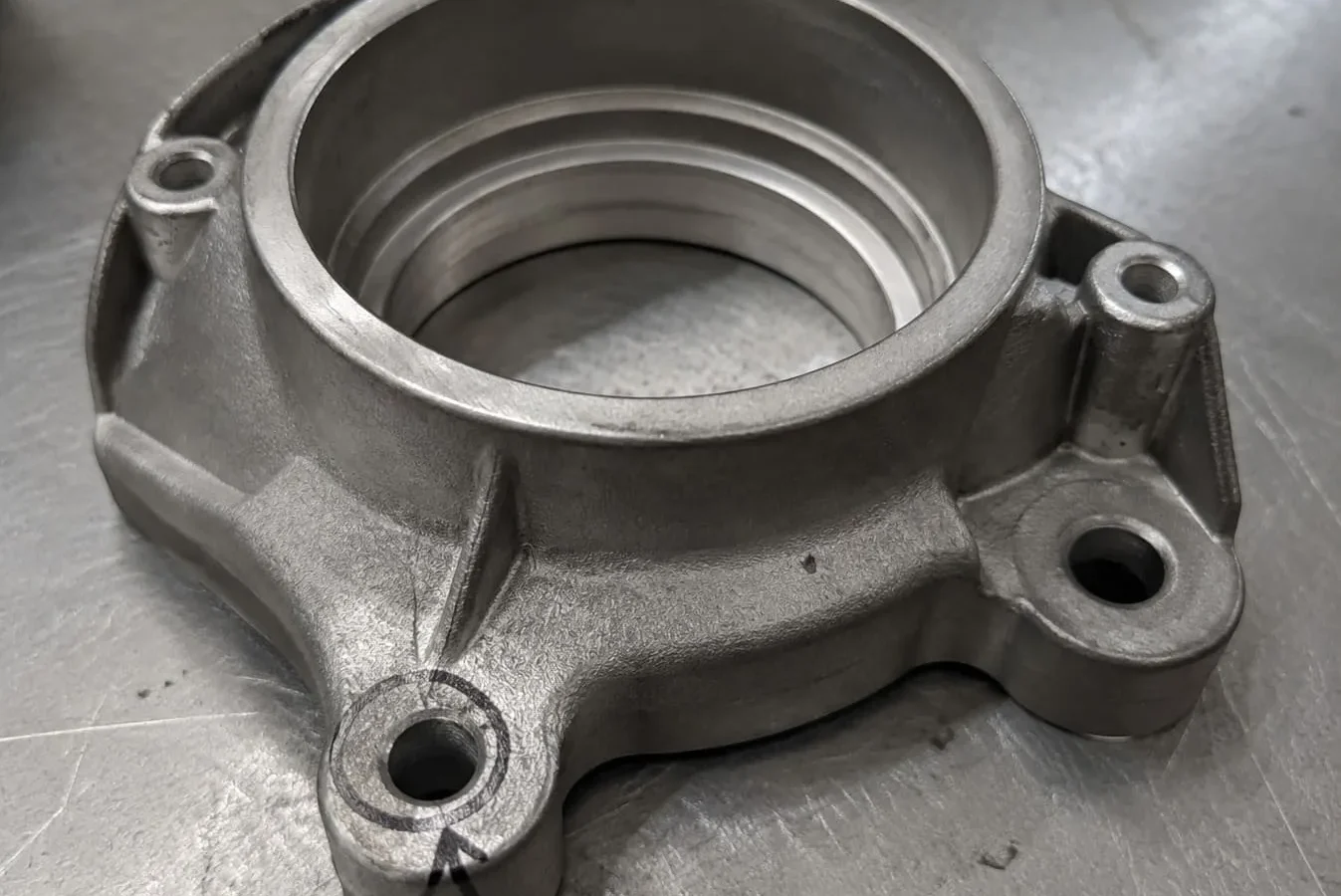 Finished ADC12 valve bracket with one assembly feature marked for dimensional review
