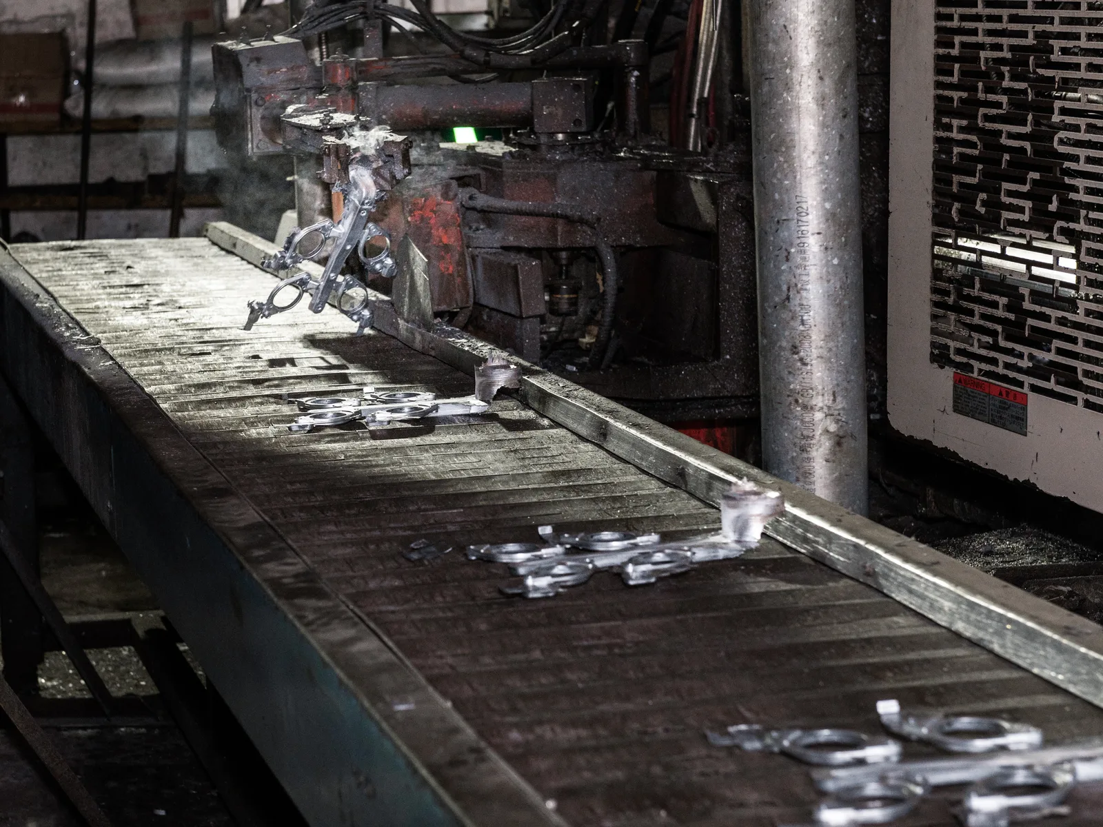 Fresh die cast components leaving the machine after ejection