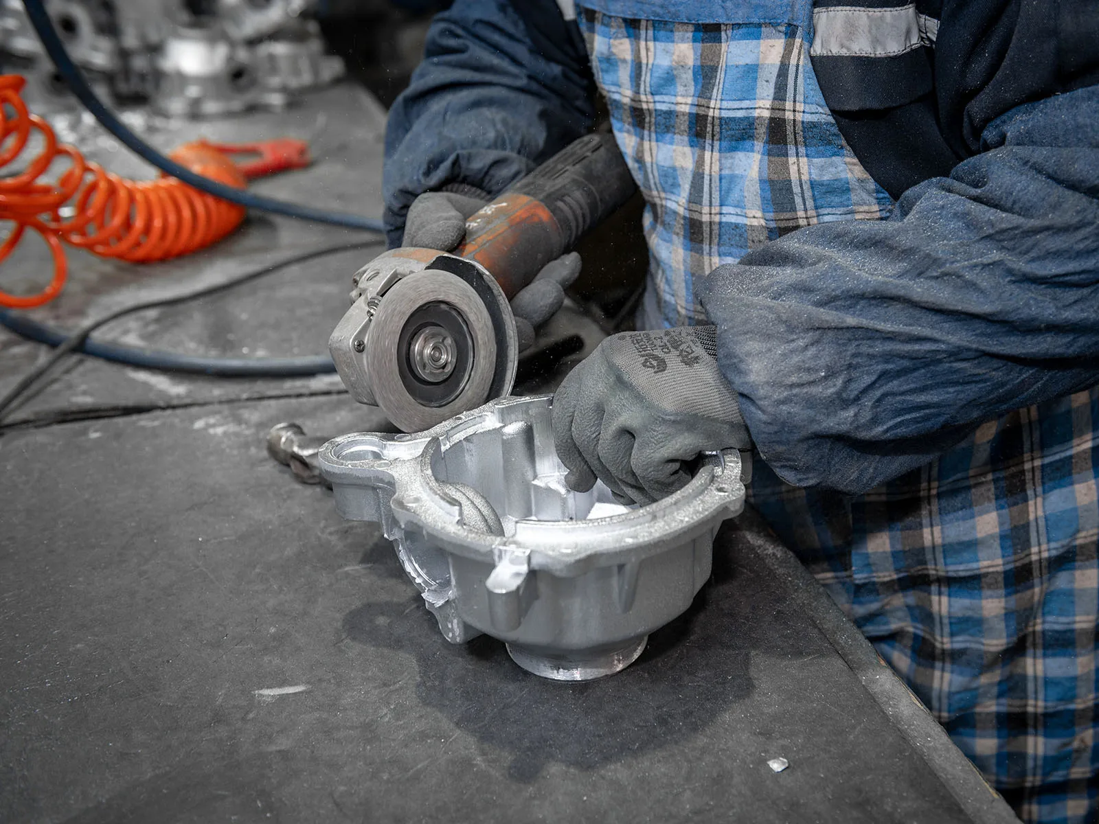 Operator removing flash from an aluminum die cast housing