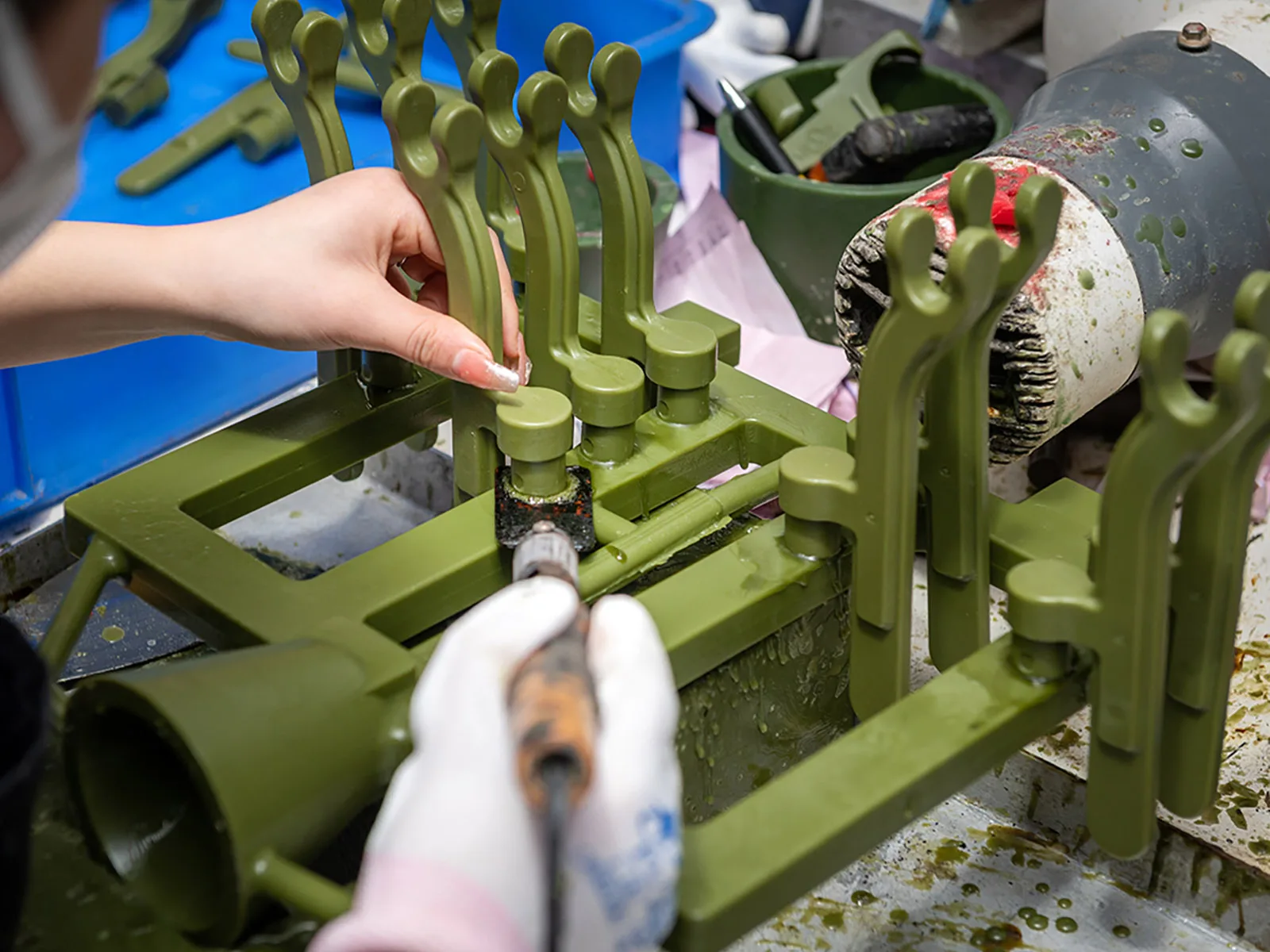 Operator assembling wax patterns onto an investment casting tree