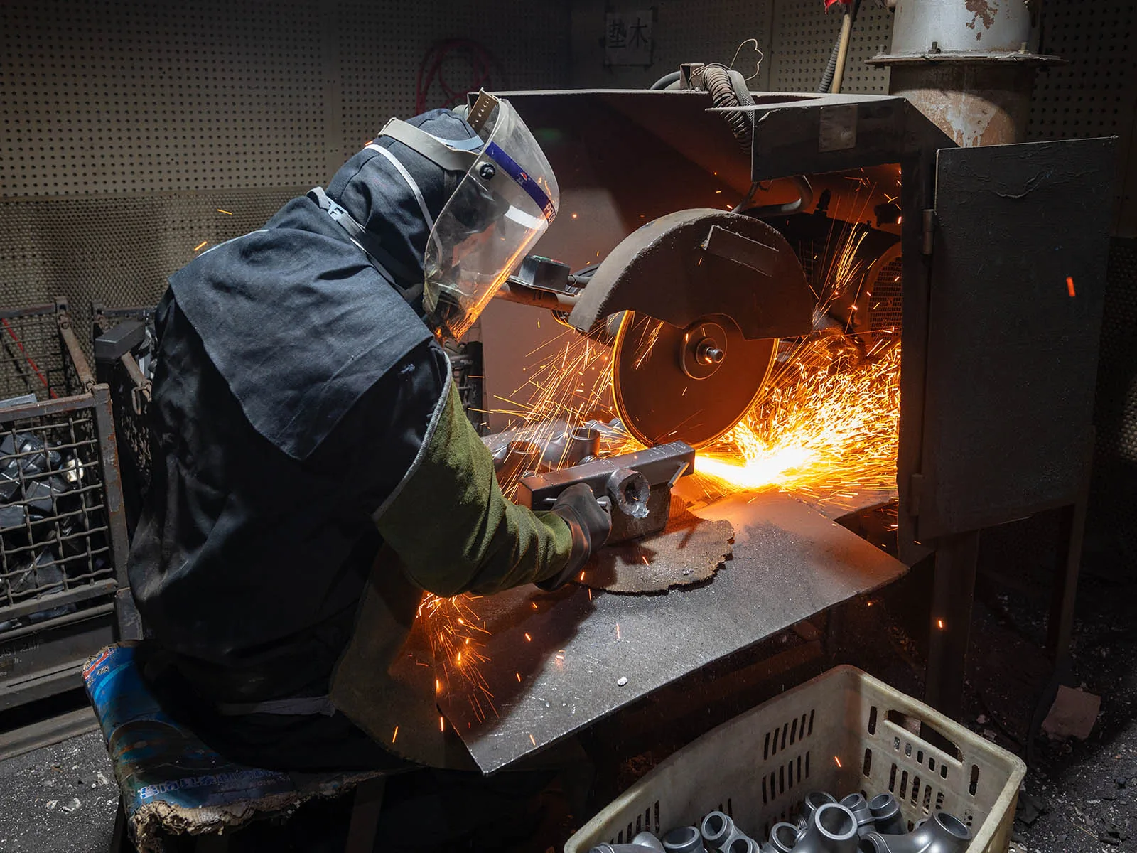 Operator cutting cast components from the metal tree