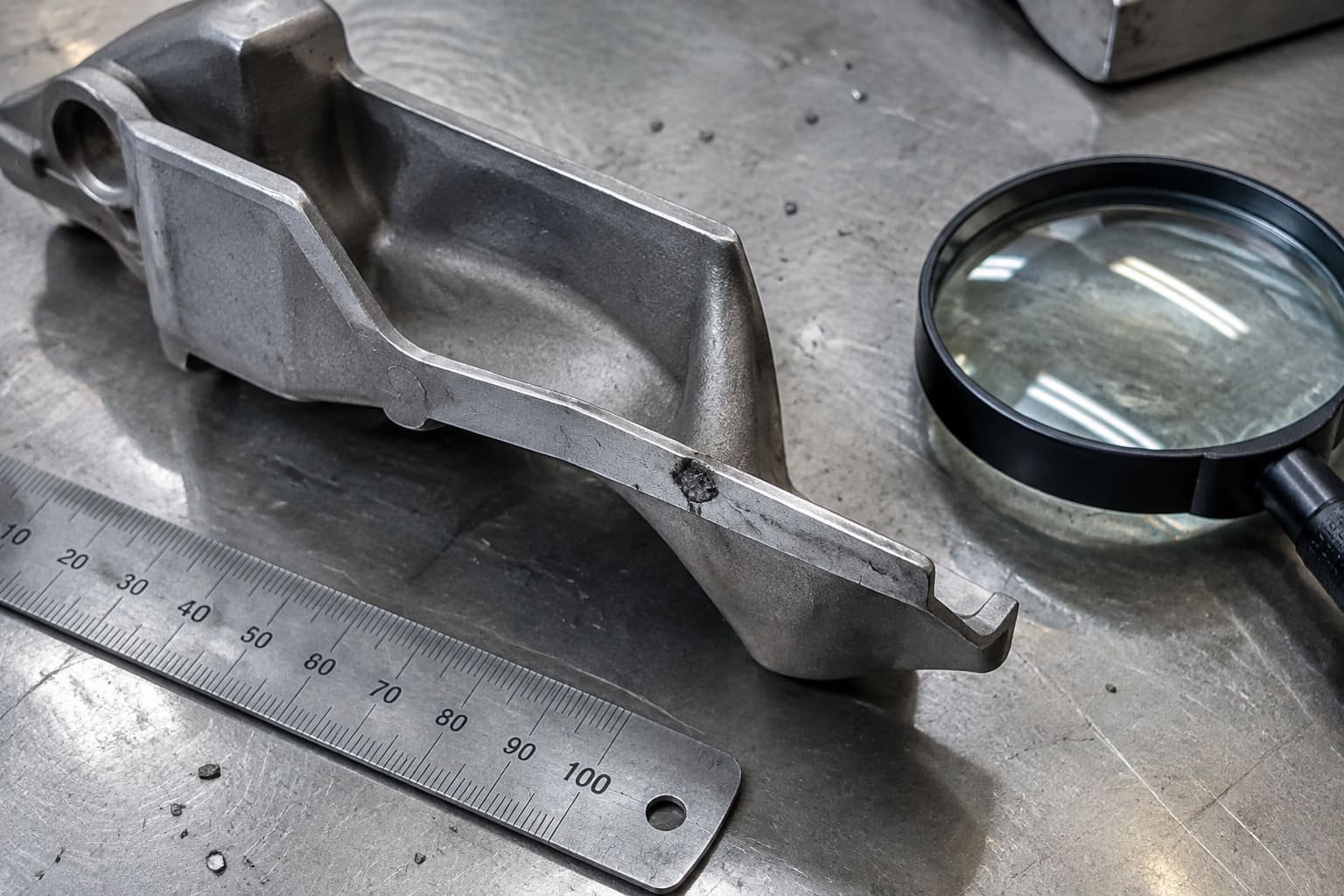 Cast wall with a localized dark surface indication beside inspection tools.