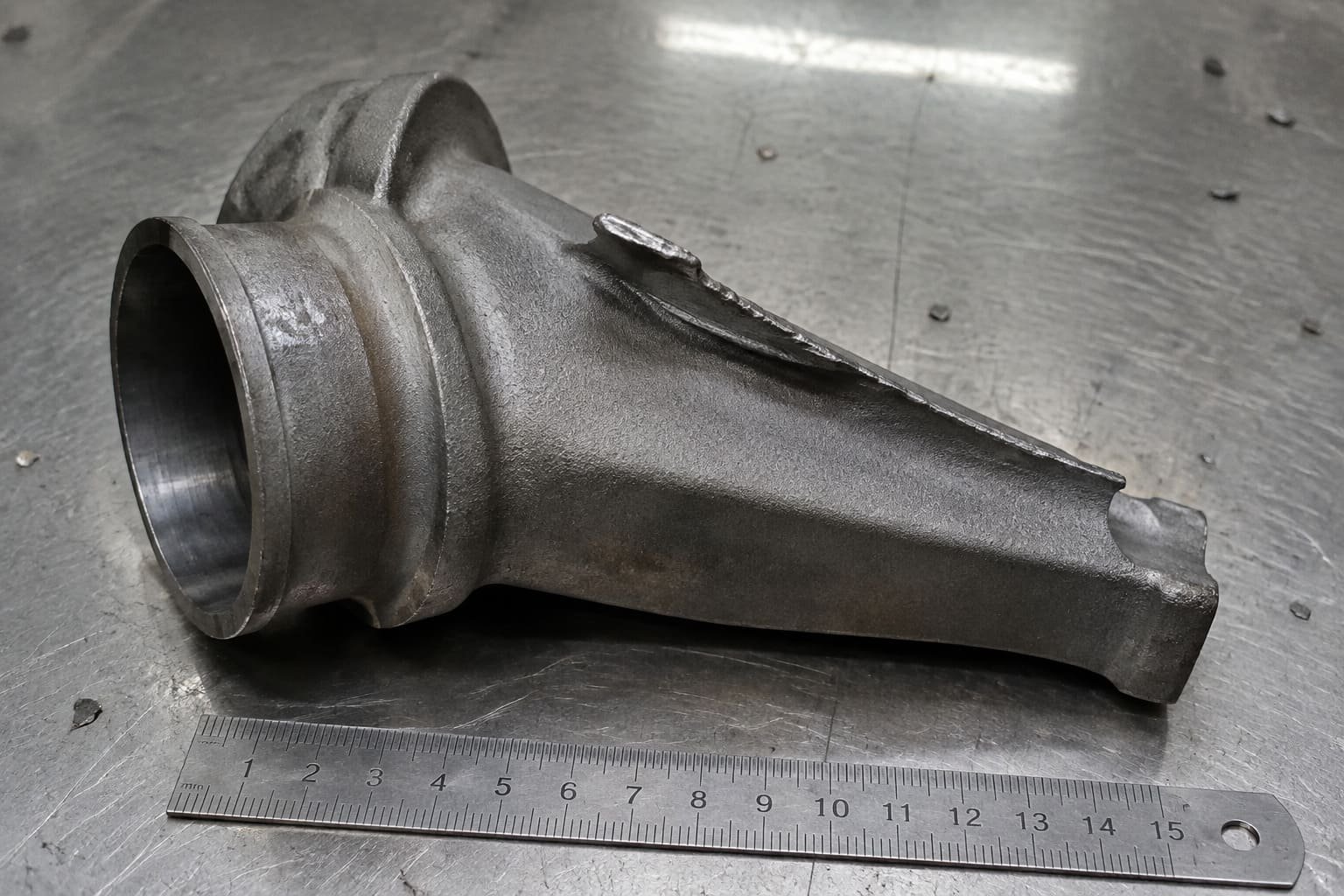 Cast component with raised irregular metal along a thin edge.